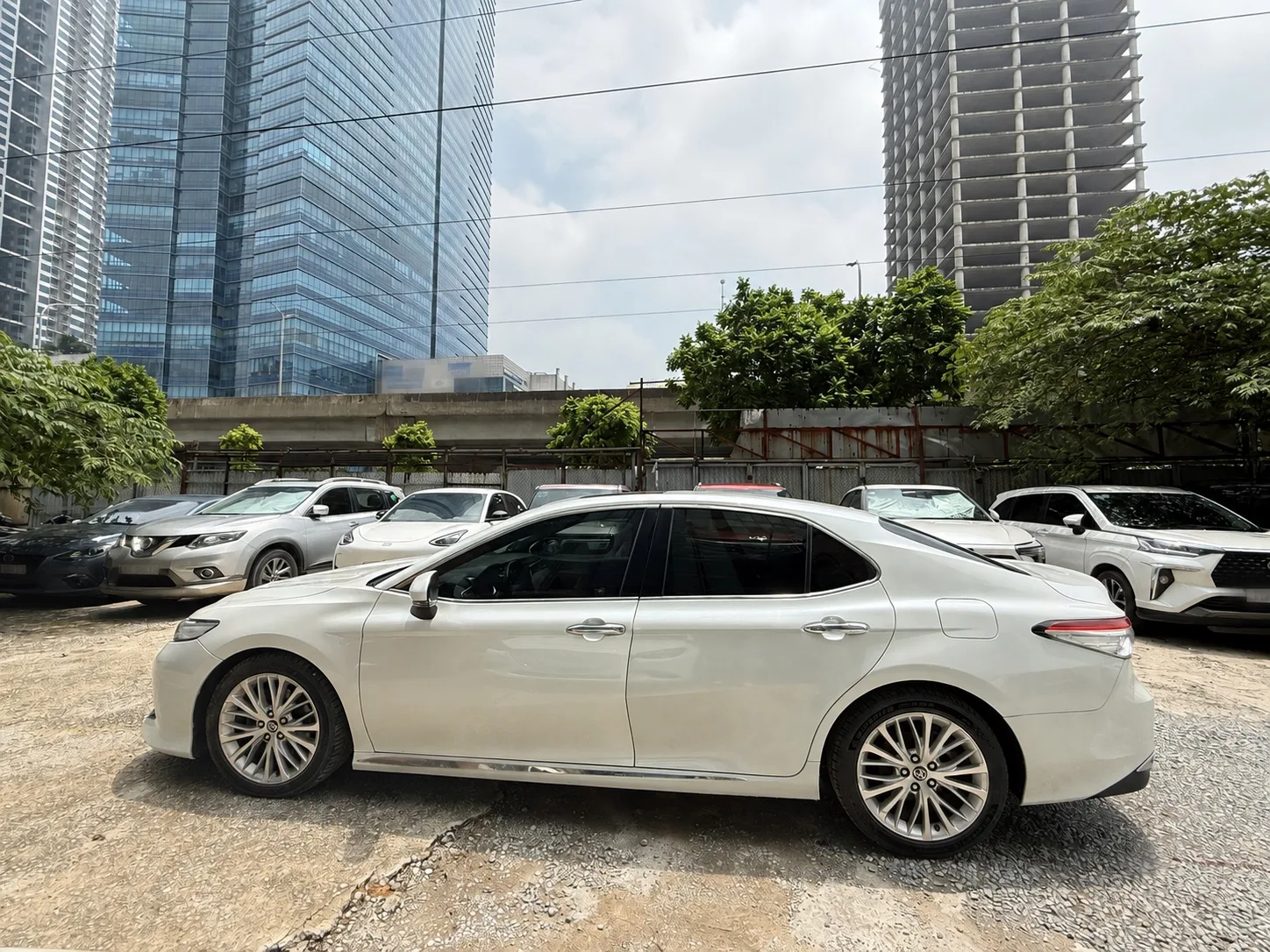 Toyota Camry màu trắng nhìn nghiêng tại bãi xe